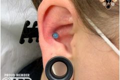 Conch piercing w/ Industrial Strength Cat's Eye gem.