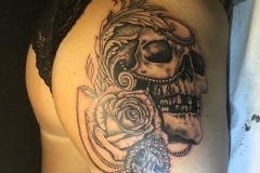 Greyscale skull with rose and jewellery.