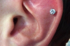 Helix piercing done with an I.S. prong set white CZ.