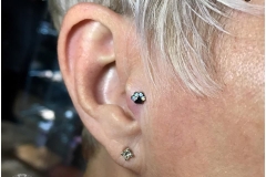 Tragus Piercing with PawPrint. Inkhaus Tattoo.